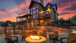 A large, modern house with a stone fireplace and outdoor seating. - Fine As Wine ~ Resort Pool, Swim-Up Bar, Pickleball, Putt-Putt & Epic Views (Sevierville)