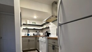 A compact kitchen with white cabinets, a built-in oven, and a refrigerator. - Private 1 bed/1bath by Downtown Columbus, Arenas, & Hospitals (Columbus)