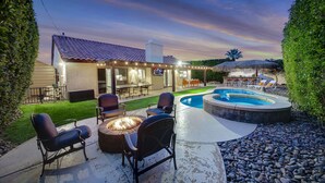 An outdoor patio with a fire pit, seating, and a swimming pool. - Bermuda Bliss: Pool, Spa, Misters, Ping Pong, BBQ! (Bermuda Dunes)
