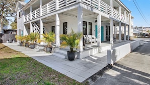 A white building with a covered porch and multiple windows. - Entire Unit Steps from the Beach | Heated Pool Access (Tybee Island)