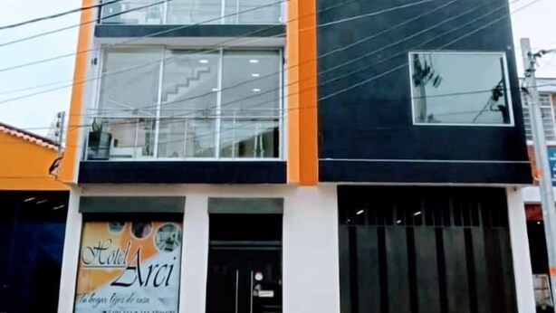 A multi-story hotel with a modern design, featuring large windows and a prominent orange accent on the facade. - HOTEL ARCI (San José de Cúcuta)