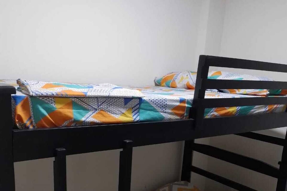 Una cama litera con una colcha estampada y una funda de almohada geométrica.