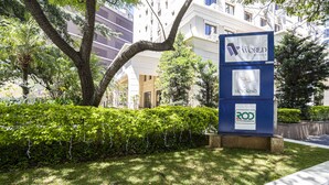 A hotel sign with "The World Hotels" and "Victorinia" logos, surrounded by greenery and a building in the background.