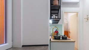 A modern kitchen with a built-in island, a sink, and a window. - Lovely and tiny unit in the City center (Trieste)