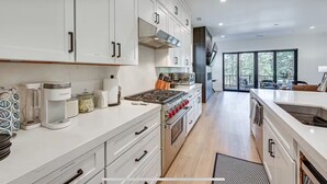 A modern kitchen with white cabinetry, a built-in stove, and a large window overlooking a deck. - New Modern House Built in 2024.  5 Beds and 3.5 Baths. 3020 SQFT (Flagstaff)