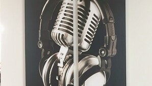 A room with a stone fireplace, a dining table, and a large black and white artwork of headphones. - Macon a Little Music House.  Family-sized Home <1 Mile to Mercer & Downtown (Macon)