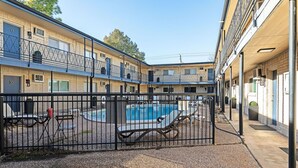 Un pati amb piscina, gandules i una zona tancada per una tanca.