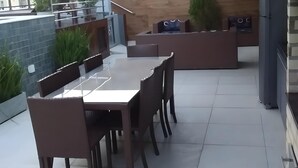 A modern kitchen with a dining area, featuring a large table and chairs, a built-in oven, and a refrigerator. - Apto a 300m da Praia de Intermares  (Cabedelo)
