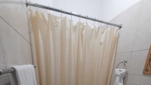 Un baño pequeño con inodoro, lavamanos y cortina de ducha.