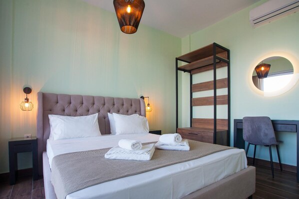 A neatly made bed with white linens, a tufted headboard, and two bedside lamps.