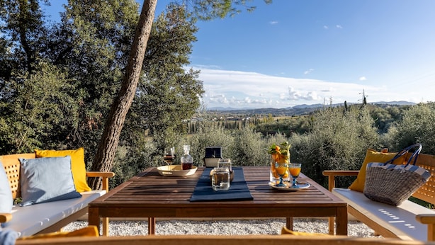 A wooden table with a view of a vineyard and distant mountains. - Villa Silvia 10 Emma Villas (Terricciola)