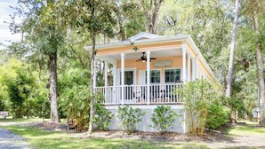 A single-story building with a porch, surrounded by trees.