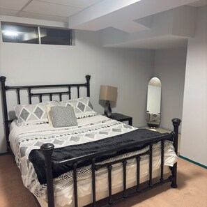 A bed with a black frame, a patterned bedspread, and pillows with geometric designs. - 3BD+Den Beautiful Bungalow | Sun Deck, Pvt Yard | Parking | 20 Mins to WEM, UoA (Edmonton)