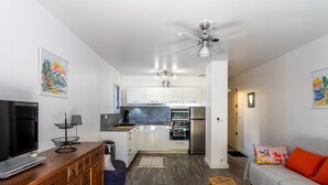 A modern apartment with a kitchenette, a dining area, a living room, and a bedroom.