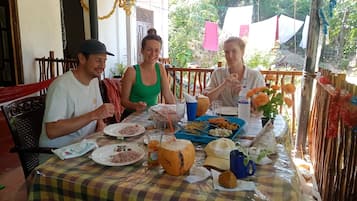 Una mesa de comedor con comida y bebidas, rodeada de sillas.
