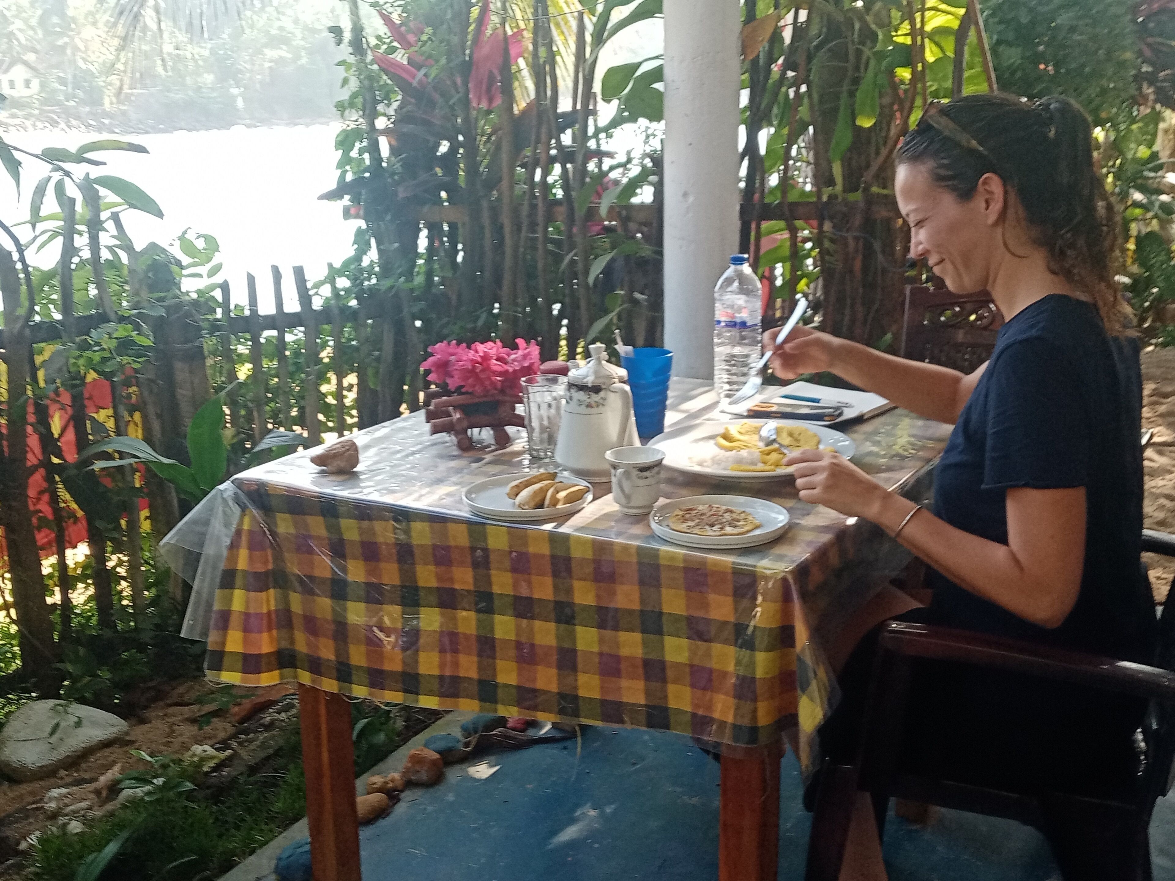 Una mesa de comedor con mantel a cuadros, platos de comida y una botella de agua.