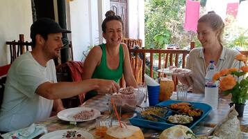 Una mesa de comedor con platos de comida, una bebida de coco y una botella de agua.