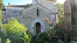 A stone building with a wooden door and a small window, surrounded by greenery and trees. - Ca na Saurina by Interhome (Crestatx)