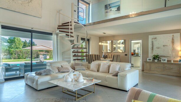 A spacious living area with a white sofa, a coffee table, and a staircase leading to an upper level. - Ca na Saurina by Interhome (Crestatx)