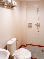 Un baño con inodoro, bidé y ducha.