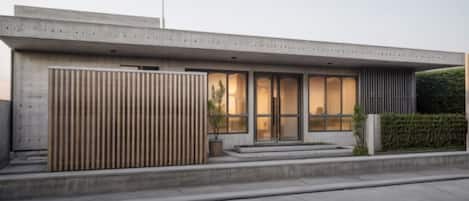 A modern building with a flat roof, large windows, and a concrete facade.