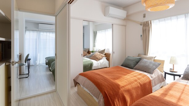 A modern hotel room with a large bed, a desk, and a mirror. - Kamata Smile House (Tokyo)