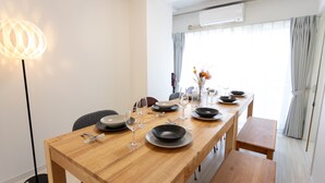 A dining area with a wooden table set for four, including plates, bowls, and cutlery. - Kamata Smile House (Tokyo)
