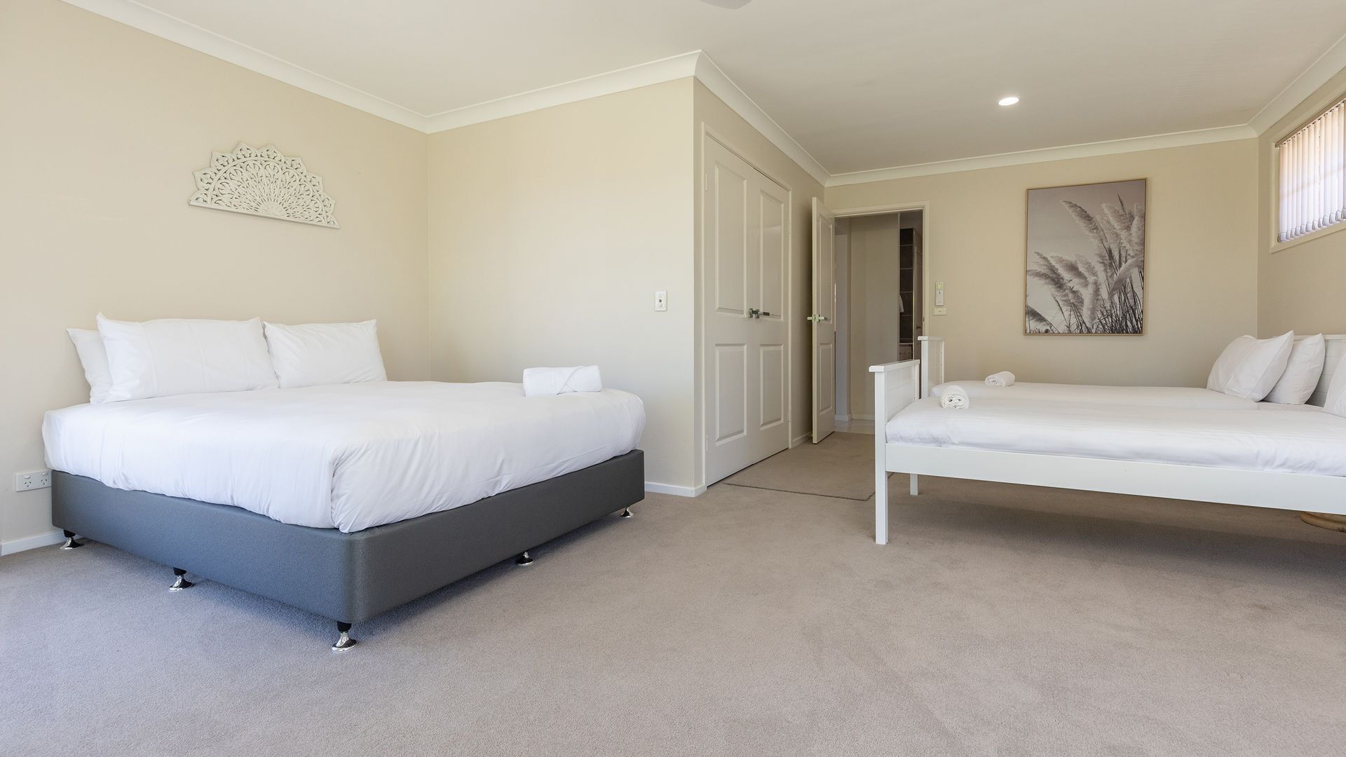 A bedroom with a large bed, a smaller bed, a wardrobe, and a door leading to a closet.