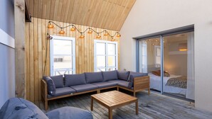 A modern outdoor seating area with a wooden ceiling, a sofa, a table, and string lights. - L'Oiseau 1 by Interhome (Dinard)