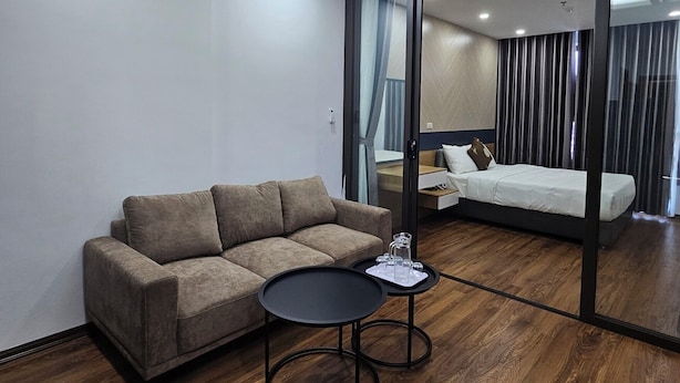 Une chambre d’hôtel moderne avec un canapé, une petite table ronde et un lit.