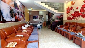 A spacious living area with leather sofas and a staircase leading to an upper level. - Minh Quan Sapa Hotel - by Bay Luxury (Sa Pa)