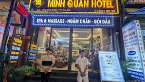 The exterior of Minh Quan Hotel with a signboard advertising SPA & MASSAGE, NGAM CHAN, and GOI DAU services. - Minh Quan Sapa Hotel - by Bay Luxury (Sa Pa)