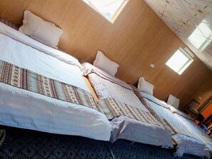Two beds with patterned bedspreads are the focal point in this simply designed room.
