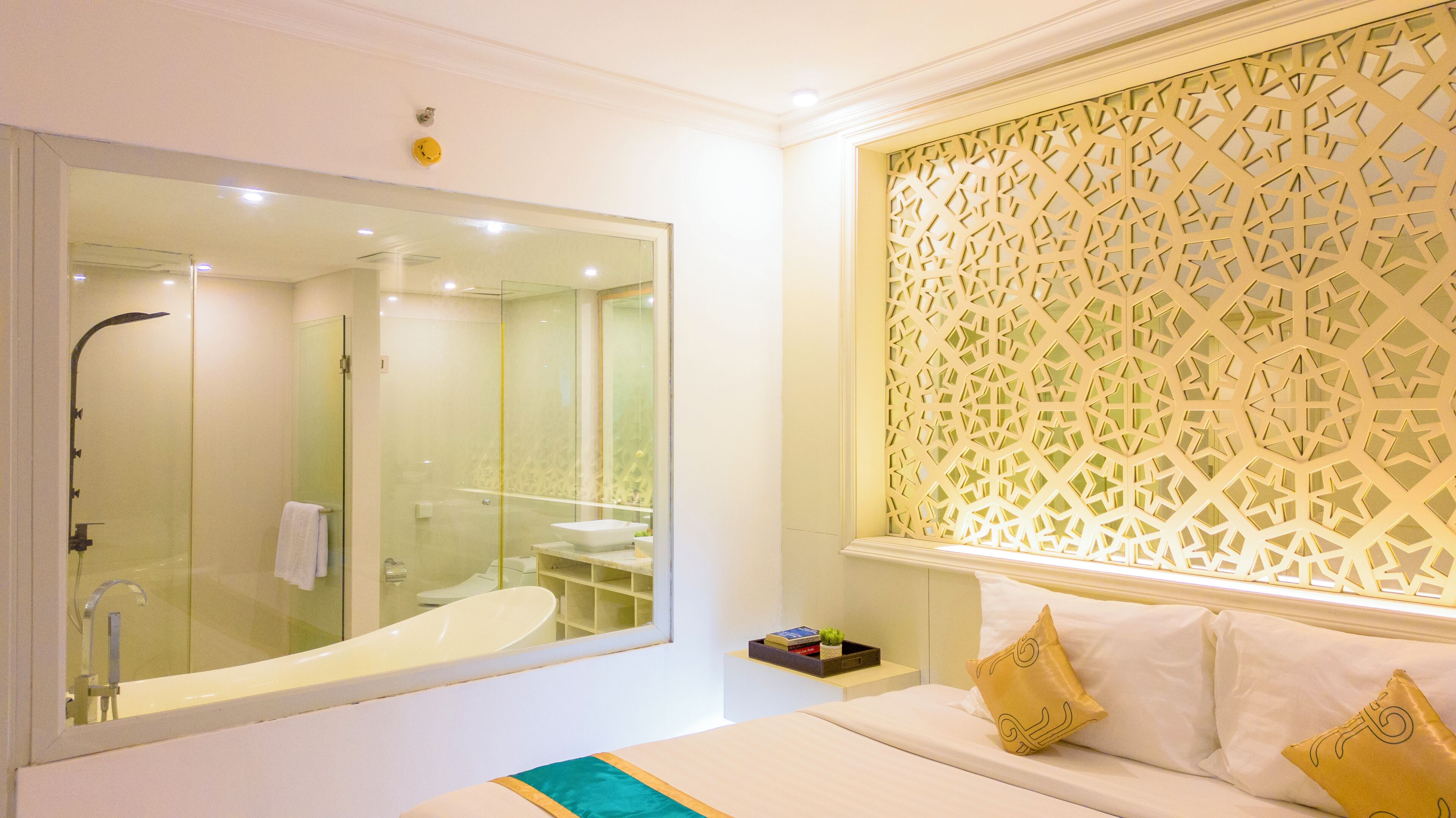 A modern bathroom with a glass-enclosed shower, a large mirror, and a decorative wall panel.