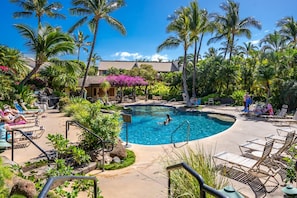 A pool area with lounge chairs, palm trees, and a building in the background. - Upscale & Luxurious Oceanview Resort Vistas (Kihei)