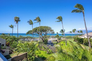 A tropical resort with palm trees, a view of the ocean, and a parking area. - Upscale & Luxurious Oceanview Resort Vistas (Kihei)