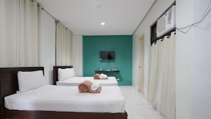 A hotel room with two beds, a television, an air conditioning unit, and a small table with toiletries. - Arzo Hotel Grand Lodge (Manila)