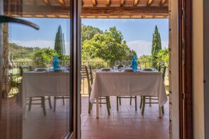 An outdoor dining area with tables set for two, overlooking a scenic landscape. - LA TENUTA - VILLINO LA TENUTA (Porto Azzurro)
