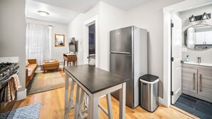 A compact kitchen with a refrigerator, stove, and wooden flooring. - 3brm/1bath North End Gem (Boston)
