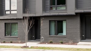A modern multi-story building with a flat roof, large windows, and a minimalist design. - The Hubb House – Relaxing Rooftop + Hot Tub (Nashville)