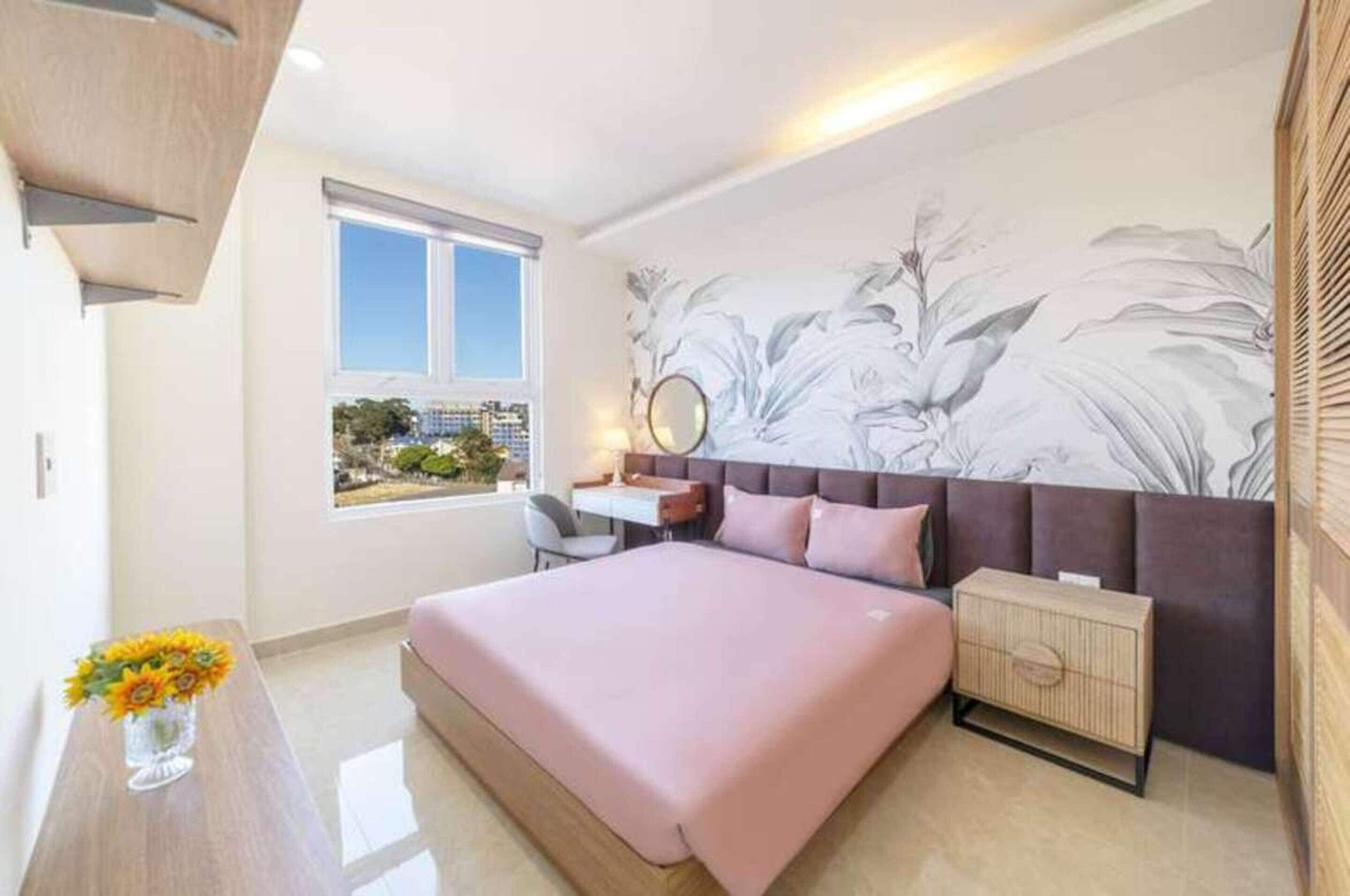 Une chambre moderne avec un grand lit, un bureau, une chaise et une fenêtre donnant sur la ville.