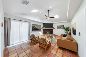 A living room with a fireplace, a sofa, a coffee table, and two chairs. - Blue Coyote Main -Clean Firepit Spacious Sunset (Yucca Valley)