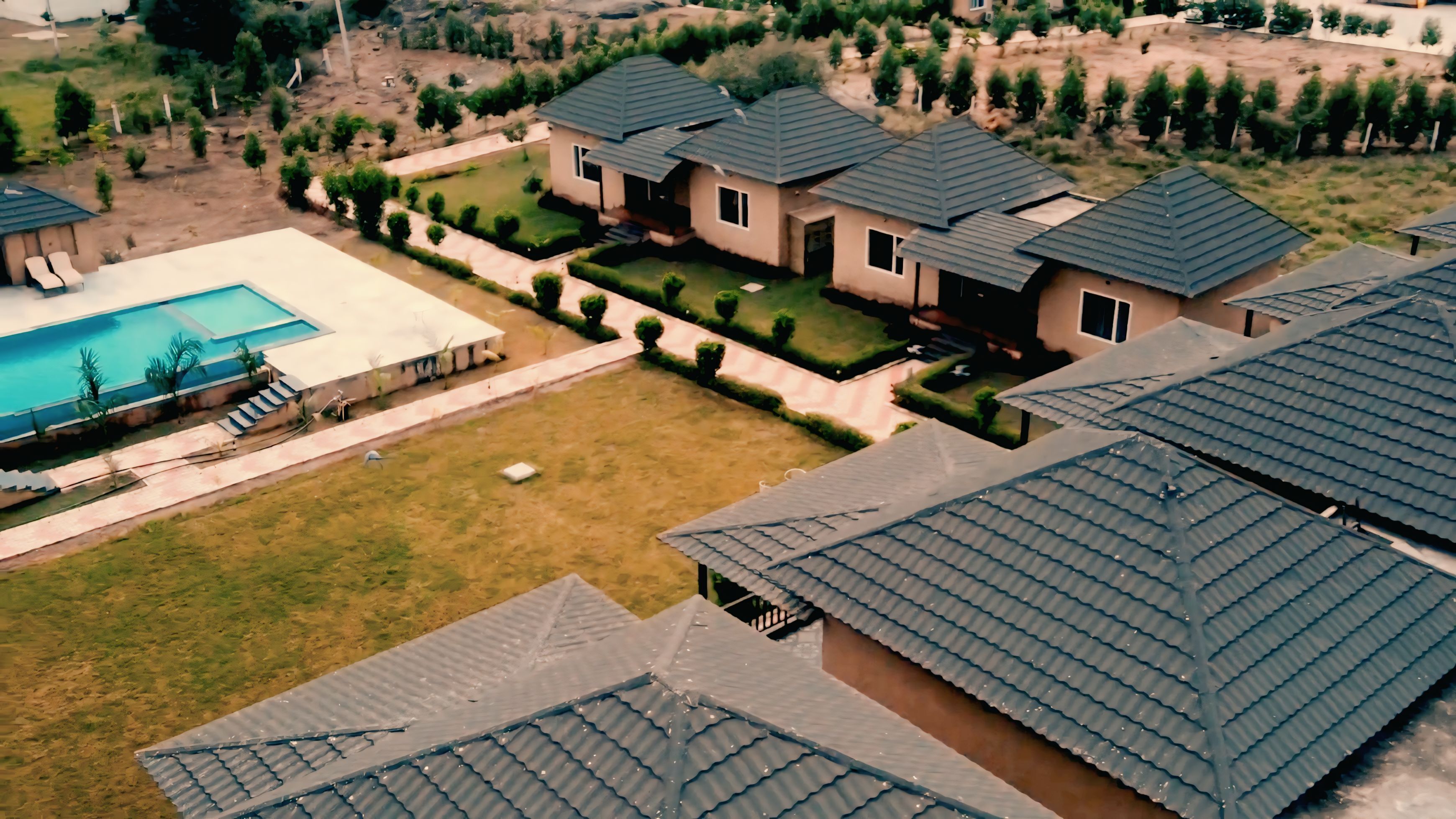 Una zona residenziale con diverse case, una piscina e prati curati.