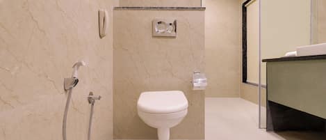 A modern bathroom with a toilet, a shower, and a sink.