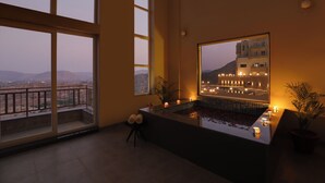 Un balcon spacieux offrant une vue sur les montagnes lointaines et sur le paysage urbain.