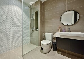 Executive appartement | Badkamer | Een douche, een haardroger, een bidet, handdoeken