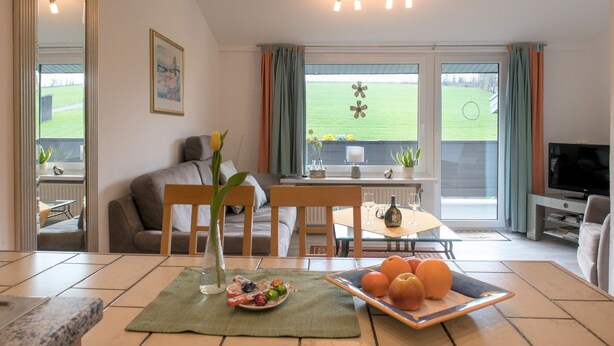 Un salon avec un canapé, une table à manger et un téléviseur.