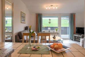 Un salon avec un canapé, une table à manger et un téléviseur.
