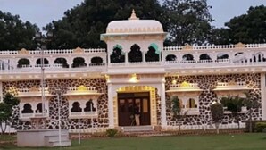 A traditional building with a central dome, arched windows, and a stone facade. - Yash Veer Resort (Sirohi)