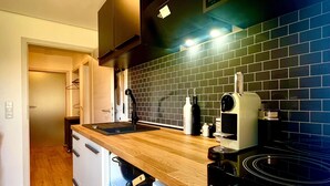 A kitchen with a wooden countertop, black appliances, and a tiled backsplash. - Holiday Apartment "Kathi‘s Allgäuliebe" with Mountain View, Private Terrace & Wi-Fi (Weitnau)